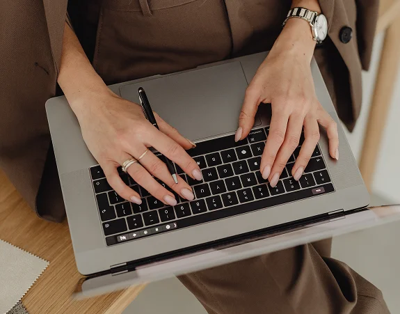 Femme travaillant à la création d'une stratégie de communication digitale sur son ordinateur.