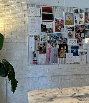 Un moodboard au mur reflétant le travail de réflexion de la maison créative pour créer une stratégie de marque.